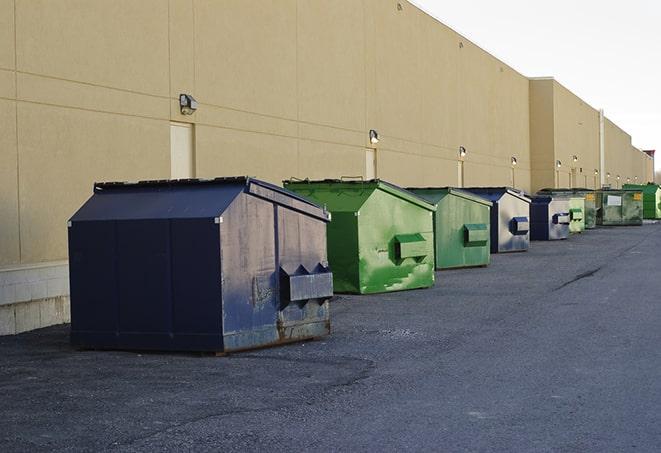 workers clearing construction waste into dumpsters in Belle Center